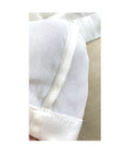 The white Lucia top shown styled, French seam detail