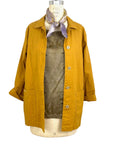 The sunrise jacket in yellow cotton linen fabric shown on a dress form styled with a silk scarf