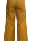 Mustard yellow wide-leg pants on a white background showing back view with big patch pockets. Woman is wearing size small.