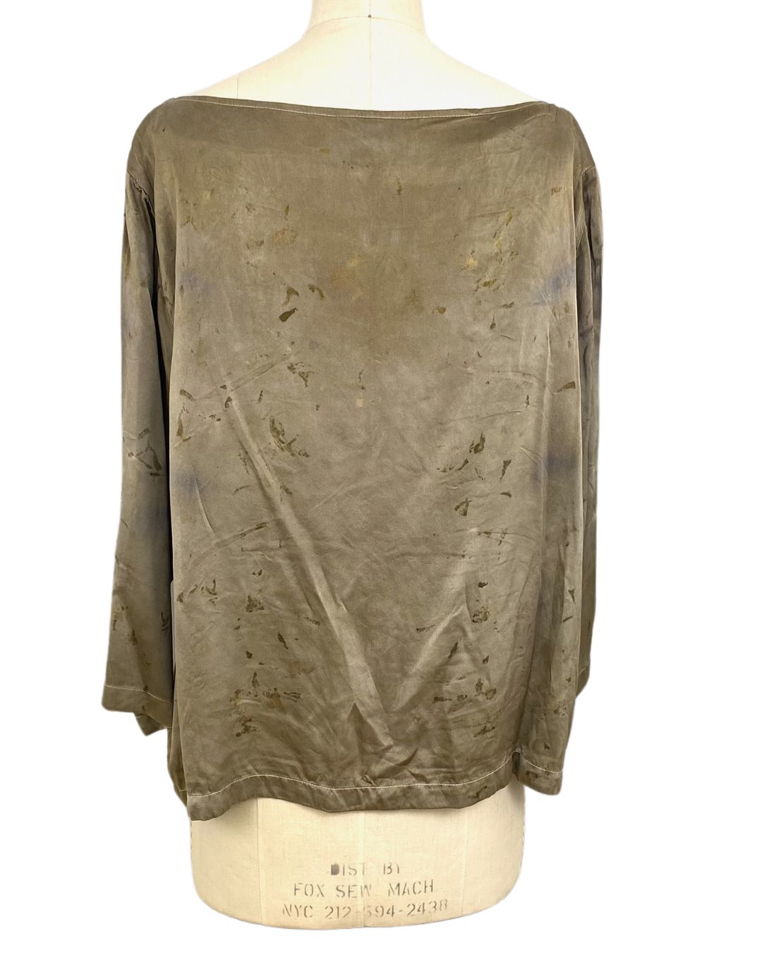 The olive green Lucia top naturally dyed floral print shown on a dress form, back view