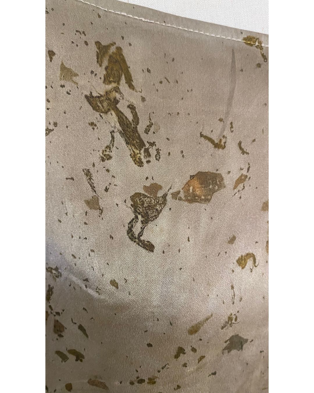 The olive green Lucia top naturally dyed floral print shown on a dress form, detail