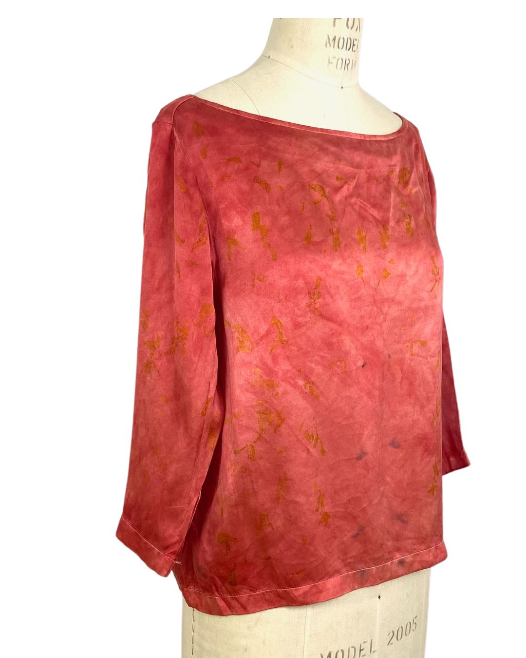The red Lucia top naturally dyed floral print shown on a dress form, side view