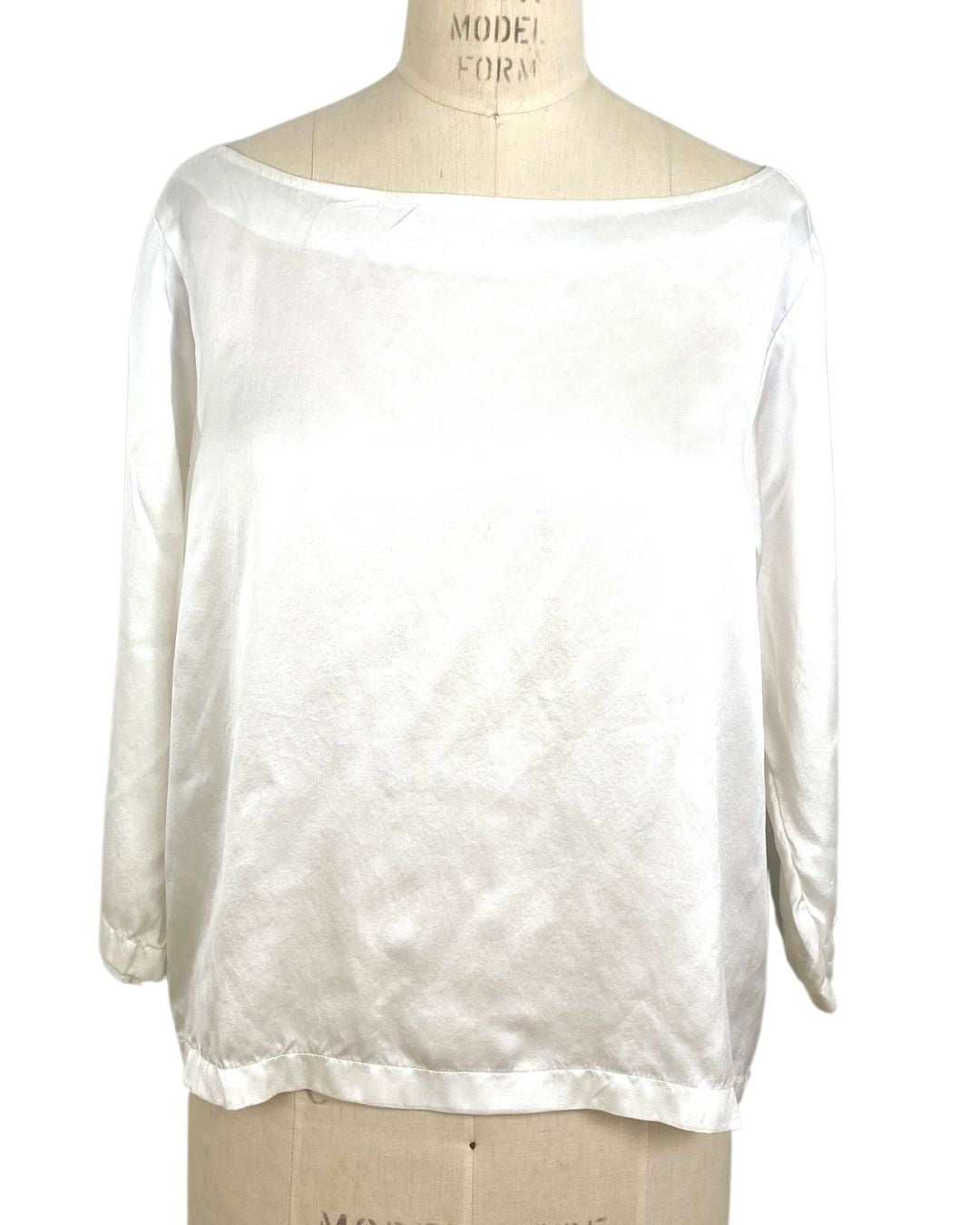 The white Lucia top shown on a dress form, front view