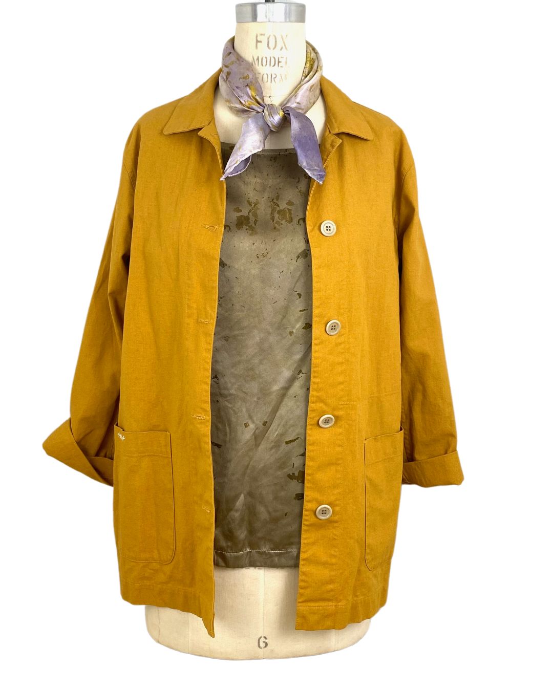 The sunrise jacket in yellow cotton linen fabric shown on a dress form styled with a silk scarf